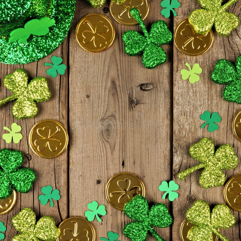 St Patricks Day square frame with shamrocks, gold coins & leprechaun hat over rustic wood. St Patricks Day square frame with green shamrocks, gold coins and royalty free stock photo
