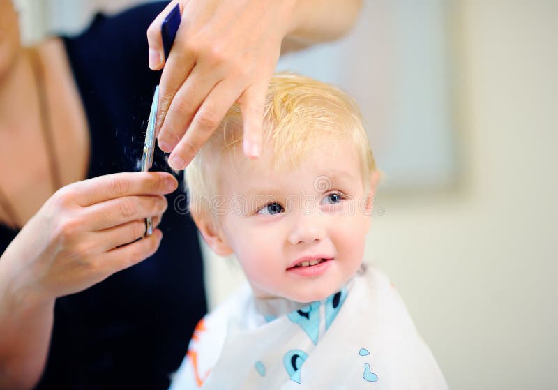 Toddler child getting his first haircut. Portrait of toddler child getting his first haircut royalty free stock images