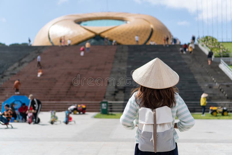 Tourist woman is wearing Non La Vietnamese tradition hat and enjoy sightseeing in lam vien square, Dalat city Vietnam.  stock photo