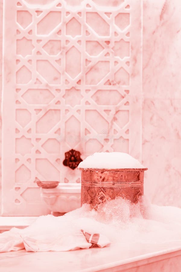 Towel and copper bowl with soap foam in turkish hamam. Traditional interior details . Living coral theme - color of the year 2019. Towel and copper bowl with royalty free stock photo