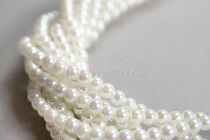 Twisted strands of white pearls. On a gray background stock photo