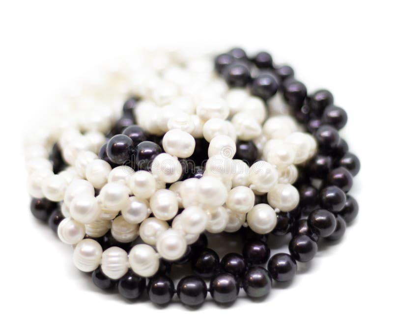 Two strands of white and black pearls on white background isolated. Two strands of white and black pearls on white background royalty free stock photos