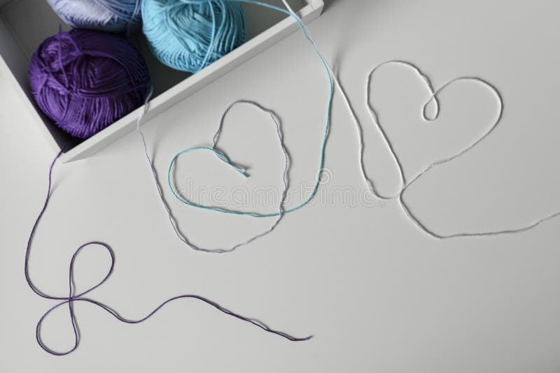 View from above on hearts from colorful wool strands coming out of the white box with knitting yarn balls. View from above on creative designed hearts from royalty free stock photo