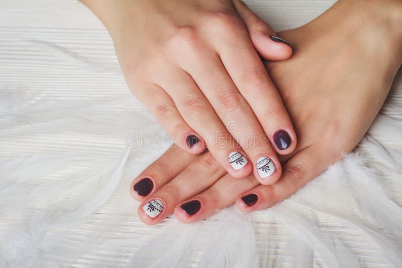 Violet nail art with printed white bow royalty free stock photography