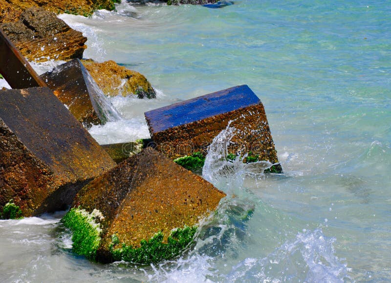 Waves Splashing on Ecology Blocks. Closeup of Indian Ocean waves splashing the surfaces of square concrete ecology blocks stock image