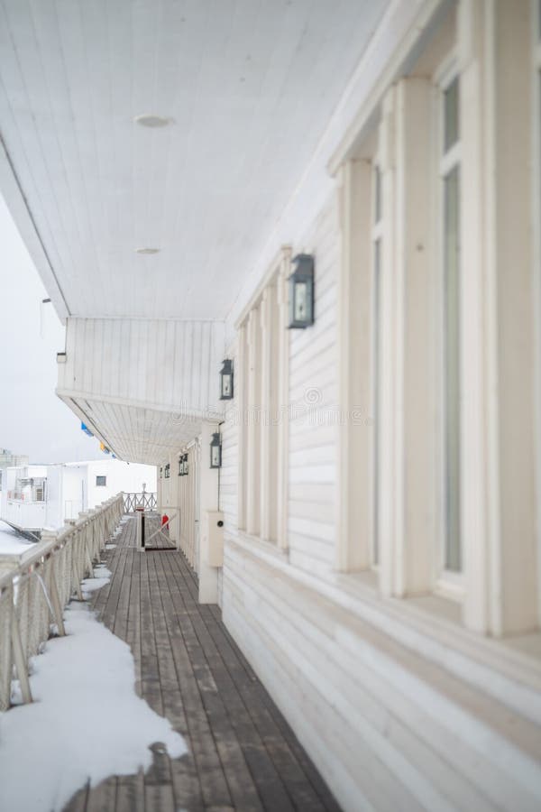 White snow on the wooden vintage open deck, old peeling paint light milky color, steel and copper lanterns hanging on the wall,. Snowy winter stock photos