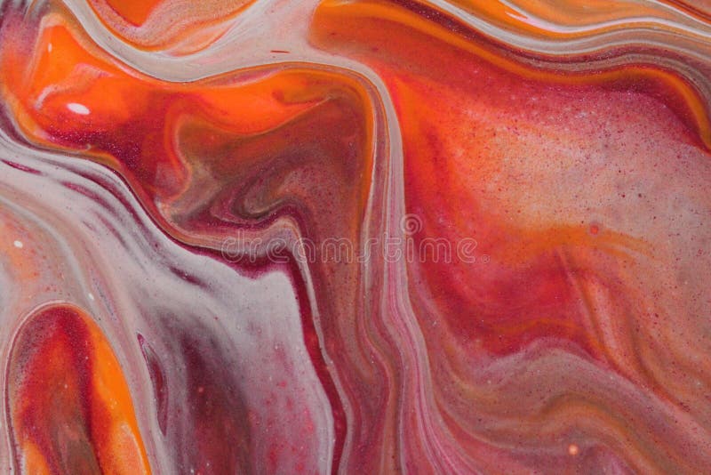 White strands stretch through warm orange and pink in this abstract background. Closeup on an abstract acrylic pour painting in a fall color palatte featuring stock photos