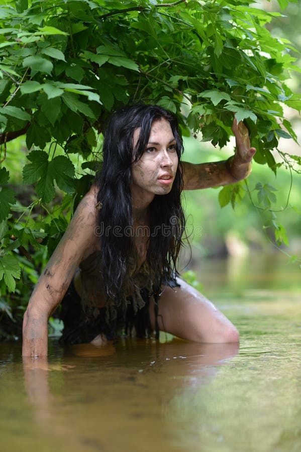 Wild young woman in black clothing. Posing in river stock images