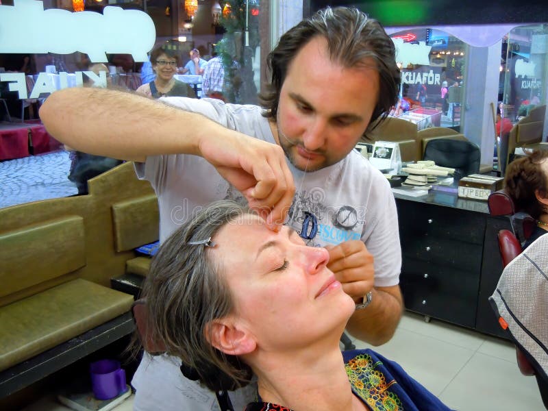 Woman having her eyebrows threaded stock photo