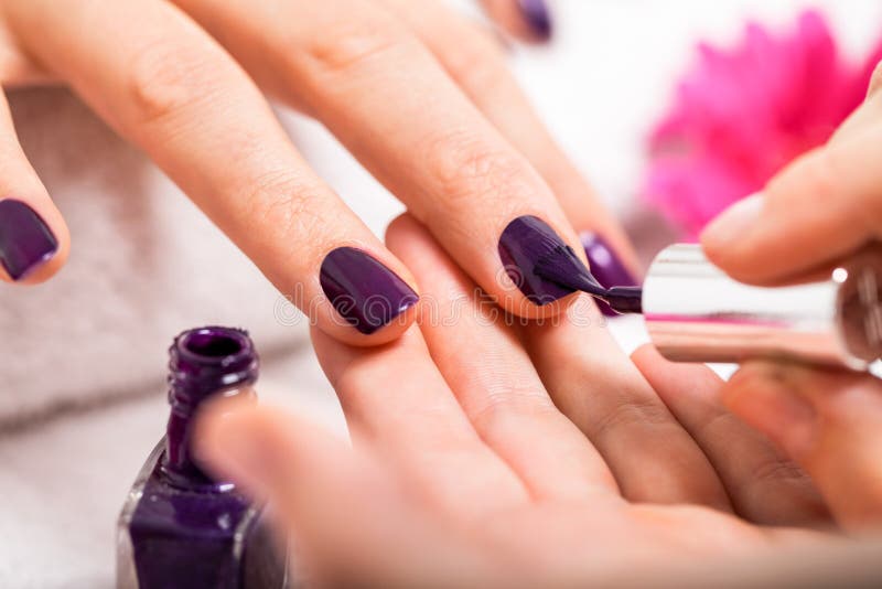 Woman having a nail manicure in a beauty salon stock photos