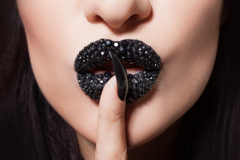 Women`s lips with black lipstick and rhinestones make tin Shhh. Black lipstick and black and white manicure stock image