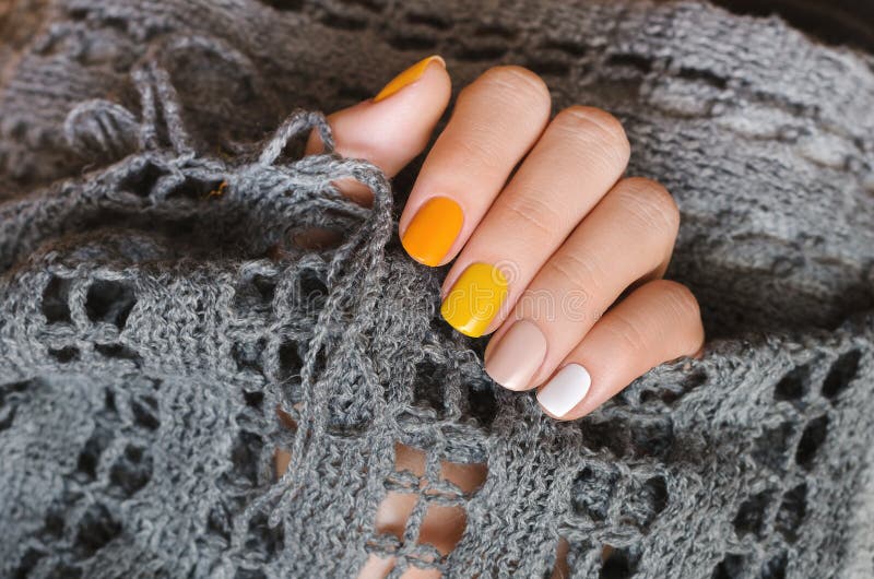 Yellow nail design. Beautiful female hand with manicure with different shades of yellow stock image