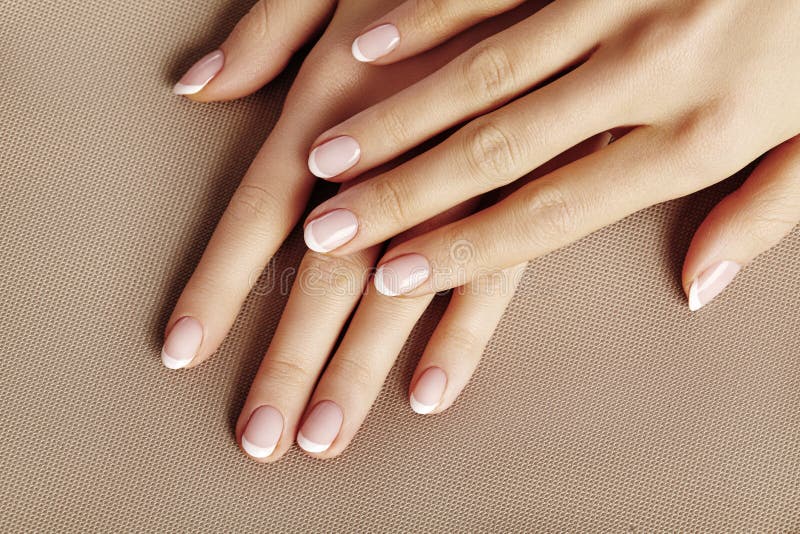 Young Female Palm. Beautiful Glamour Manicure. French Style. Nail polish. Care about Hands and Nails, clean Skin royalty free stock images