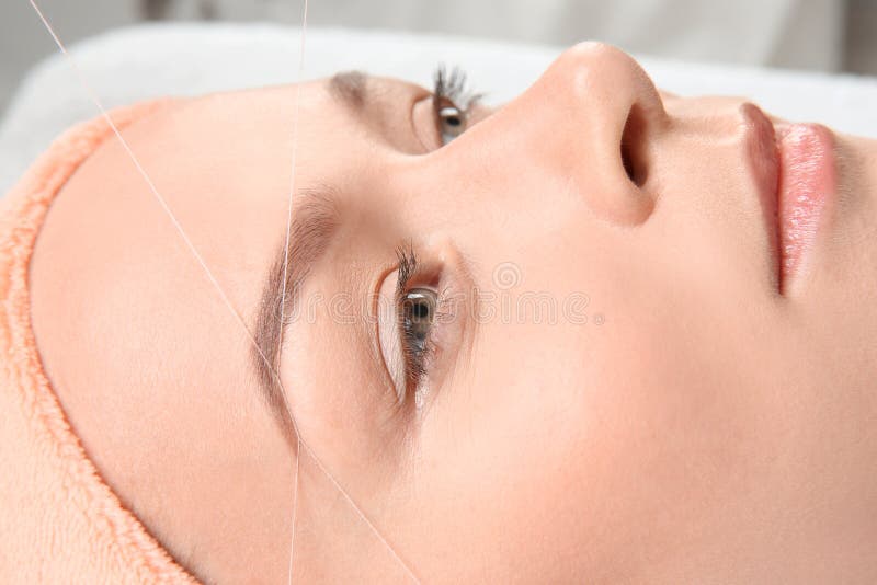 Young woman having eyebrow correction procedure. In beauty salon, closeup royalty free stock image