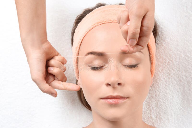 Young woman having eyebrow correction procedure. In beauty salon stock photo