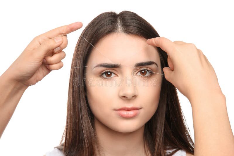 Young woman having eyebrow correction procedure. On white background royalty free stock photos