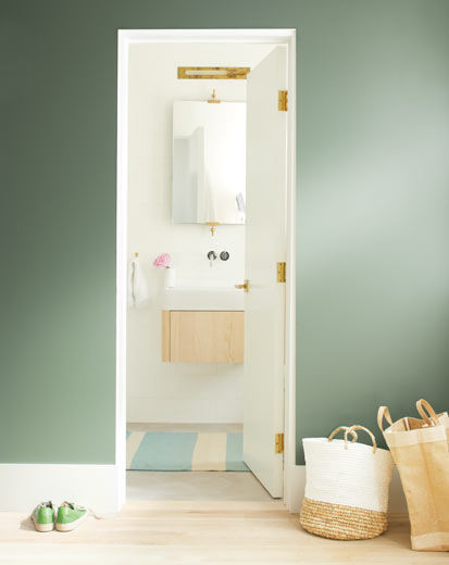 A dark green wall leads to a bright, neutral bathroom A dark green wall leads to a bright, neutral bathroom