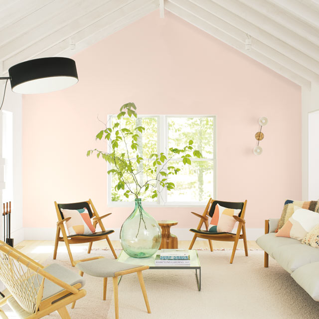 A casual living room with a light pink-painted accent wall A casual living room with a light pink-painted accent wall